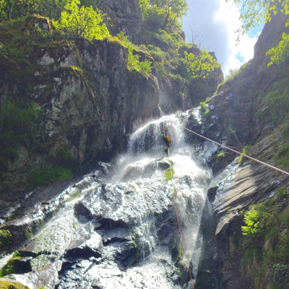 séjour en suisse sejour canyoning dans le tessin agence de voyage agence de canyoning canyoning riom chatelguyon chatel-guyon aubière pont-du-chateau vertaizon chamalières clermont-ferrand durtol royat romagnat perignat les sarliève riom sport adrénalive sports extrèmes Descente en rappel le long d'une cascade pendant une initiation au canyoning Descente en rappel sous une cascade dans un canyon alpin du Tessin moniteur canyoning guide canyoning toboggan naturel vasque naturelle rappel en cascade